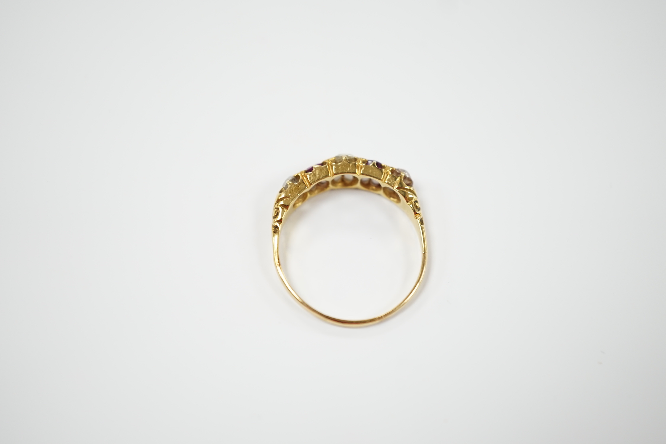 An early 20th century yellow metal, three stone old cut diamond and two stone garnet? set half hoop ring, size U/V, gross weight 3.2 grams.